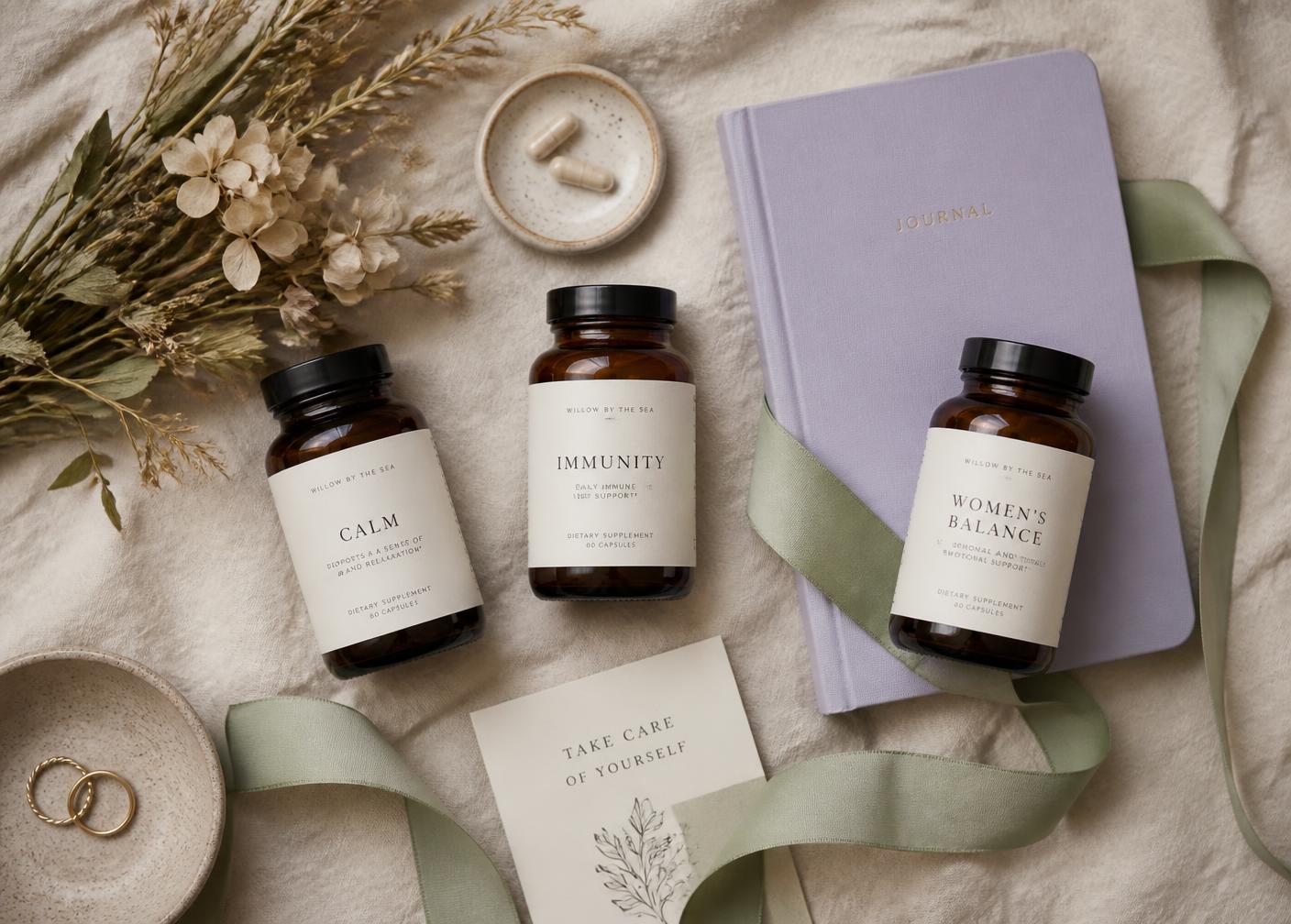 Amber supplement bottles, a lavender journal, and dried flowers on cream linen